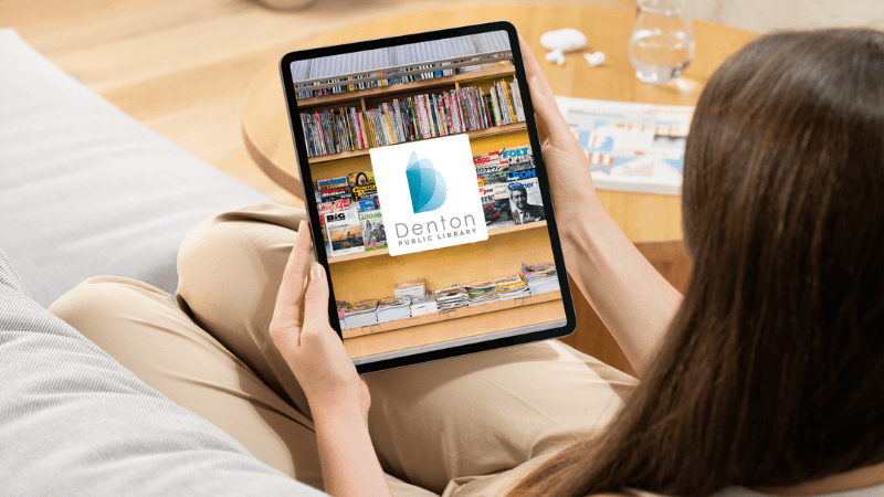 A woman looking at a tablet showing the Denton Public Library logo